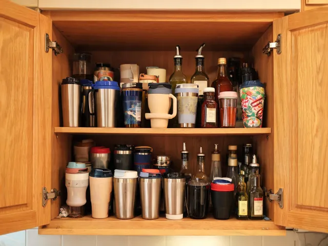 Messy cabinet before organizing drinkware